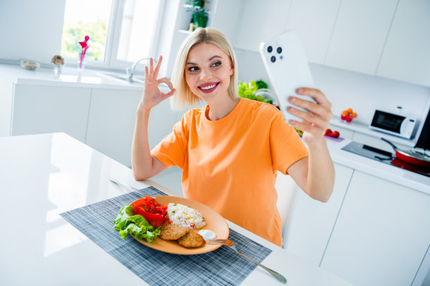 照片迷人的幸福的人拿着智能手机自拍秀好符号美味的米饭肉蔬菜盘公寓室内图片下载