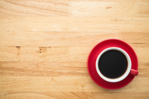 顶部视图的红色滴咖啡杯在木桌背景与复制空间最小的风格。图片下载