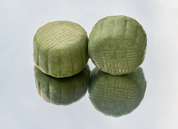 美味的两绿月饼是用芋头、黑芝麻和金线蛋在白色的背景上反射出来的。图片下载