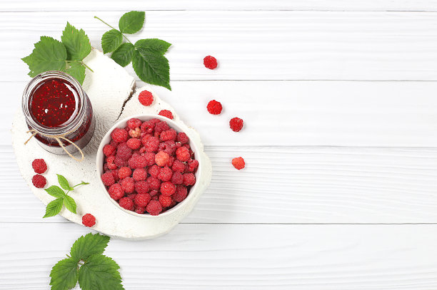 村庄收获，树莓果酱坛子在浅色木制背景与树叶，商店横幅和广告，健康的天然食品理念，早餐与配料图片下载