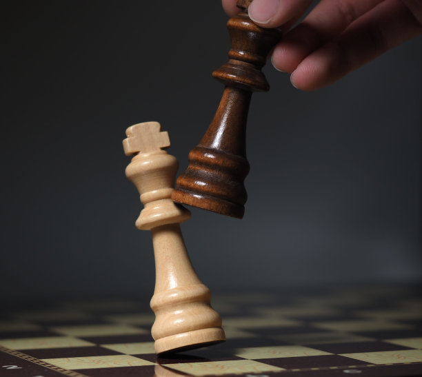 手放在棋盘上，棋子飞扬。多云的背景图片下载