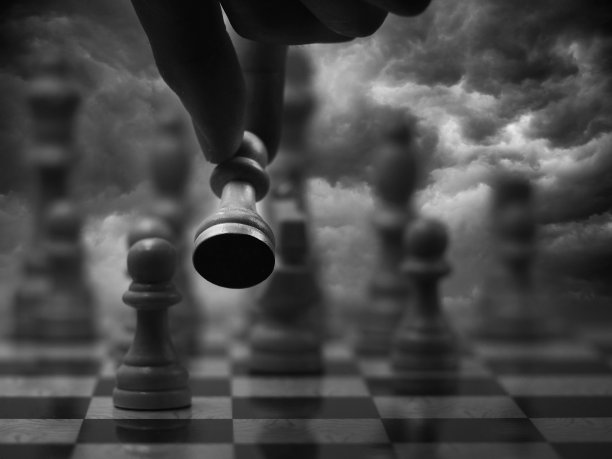 手放在棋盘上，棋子飞扬。多云的背景图片下载