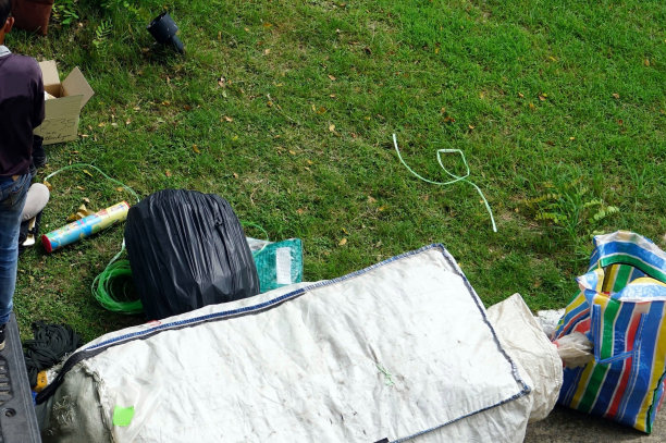 一名工人正在车上收集垃圾袋以便回收。图片下载