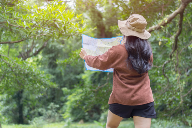 爱冒险的亚洲女孩在泰国美丽的森林里用地形图旅行和导航。图片下载