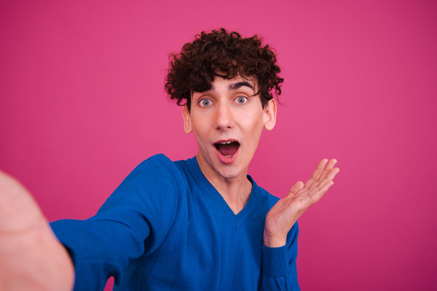 运动和健康的生活方式。有趣的情绪化的家伙在粉红色的背景上摆姿势。图片下载