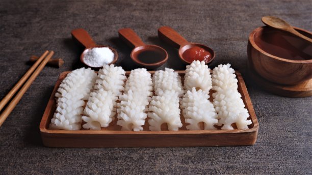 新鲜的鱿鱼放在方形木盘上，经过清洗和切割，像花一样，在小木勺上放上一些酱和盐。图片下载