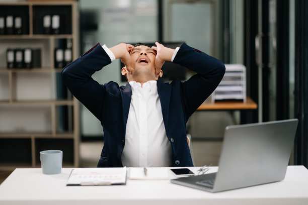 劳累过度的年轻亚洲商人办公室职员在办公桌前工作了一整天后颈部疼痛。办公室综合症概念图片下载