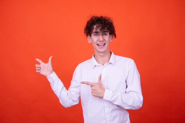 从事广告工作。有趣的家伙在橙色背景上摆姿势。图片下载