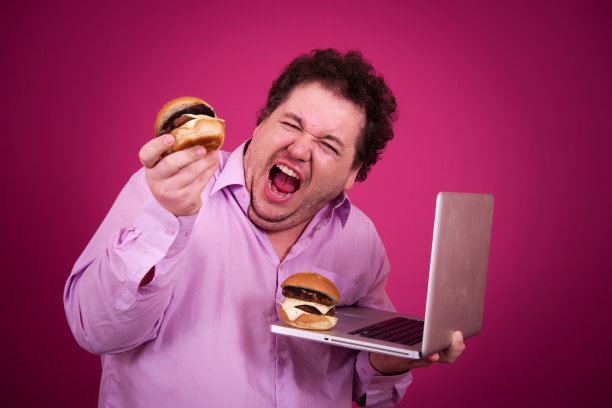 滑稽的胖子正在健身，并且贪婪地吃了一个汉堡包。复古的风格。图片下载