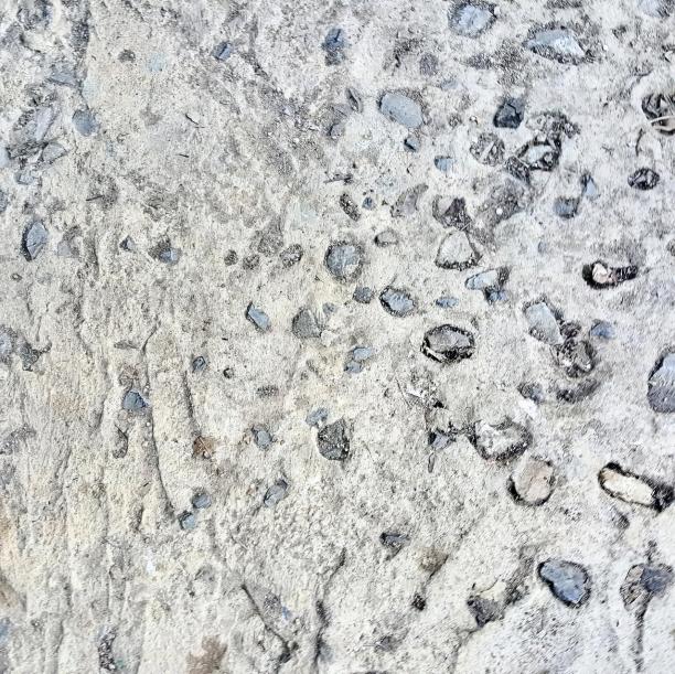 一张岩石和砾石表面的特写照片，水的气泡以一种模式散落在地面上。图片下载