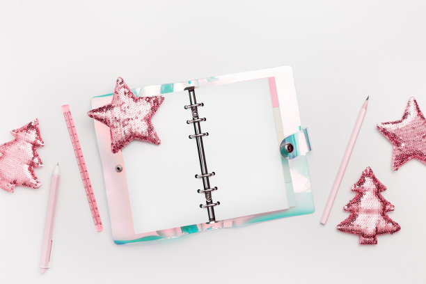 新年规划概念，女孩工作空间，打开空白的练习本或日记本，钢笔，铅笔，白色上的粉色金属色圣诞树和闪亮的星星。假日学校文具的趋势平平图片下载