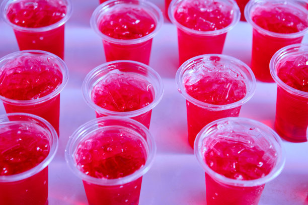 很多用塑料杯装的冰红色饮料图片下载