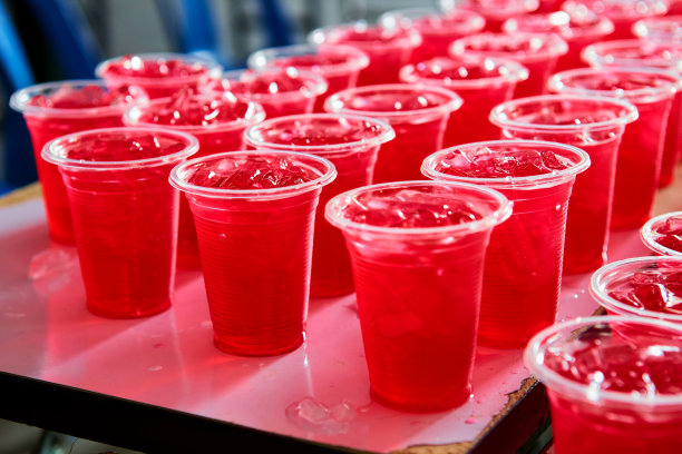 很多用塑料杯装的冰红色饮料图片下载