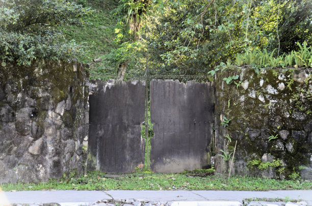 一扇正在使用的铁门和木头，还有一堵石墙图片下载