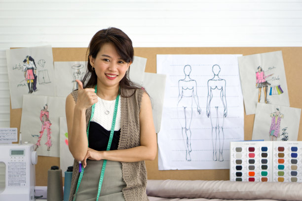 裁缝举起大拇指。那台笨重的缝纫机就在她旁边。机器周围堆满了五颜六色的线轴、不同质地的织物碎片和一个卷尺图片下载