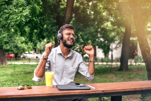 夏天在咖啡馆听音乐的亚洲商人。图片下载
