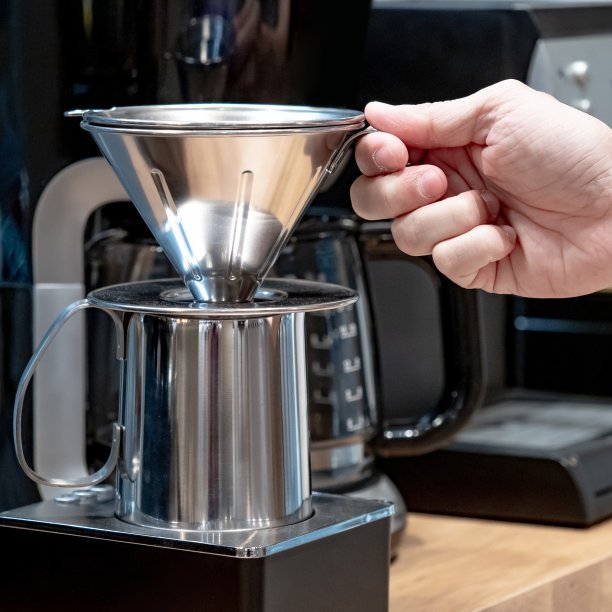 购买咖啡机设备。咖啡师工具店的男性手持不锈钢咖啡滴管。图片下载