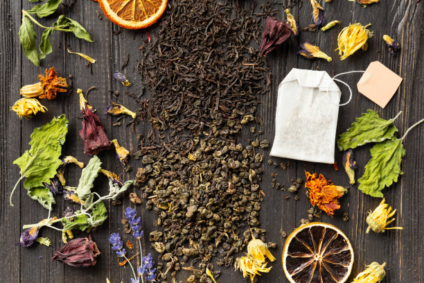 干绿茶和红茶，茶包，花茶在黑暗的背景上俯视图特写。图片下载