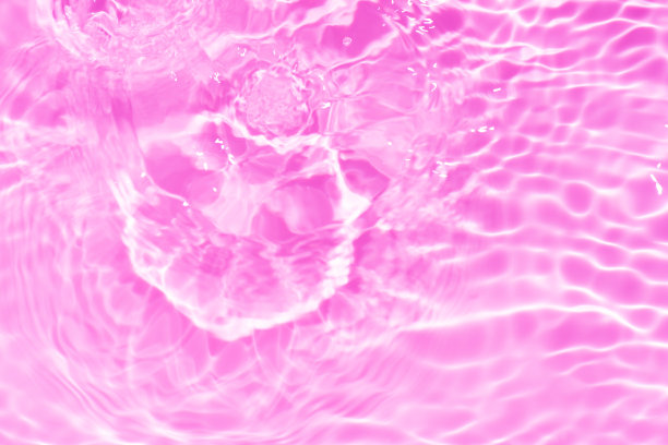 紫色的水面上泛起涟漪。散焦模糊透明粉红色透明平静水面纹理与飞溅和泡沫。水波与闪亮的图案纹理背景。图片下载