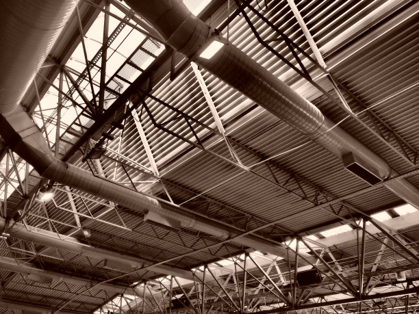 机库、生产车间或体育馆的屋顶金属结构、梁、支撑元件。大厅和房间的通风系统。天窗。工业内部。图片下载