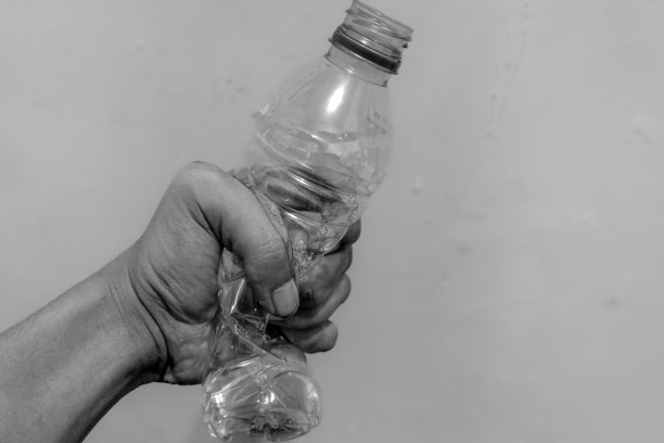 手握并挤压着一个塑料水瓶。图片下载