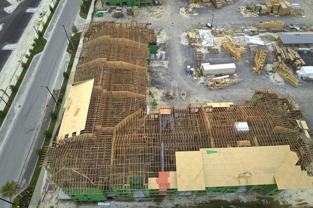 鸟瞰图未完工的公寓楼框架准备安装在建的木制屋顶梁。美国郊区住宅的发展。美国房地产市场图片下载
