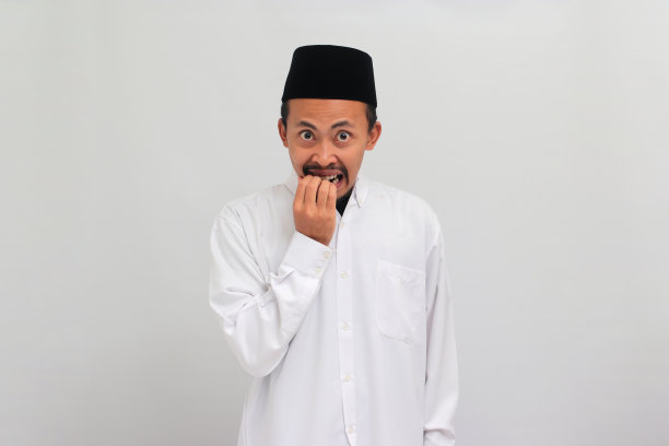 一名年轻的印尼男子困惑地咬着指甲，紧张地看着镜头图片下载