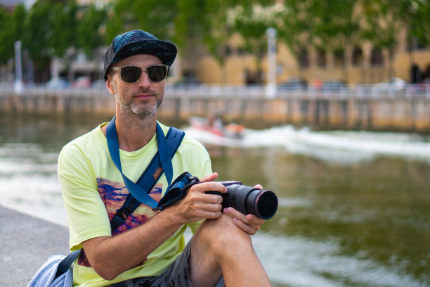 戴着帽子戴着墨镜的男人用相机捕捉城市的瞬间图片下载