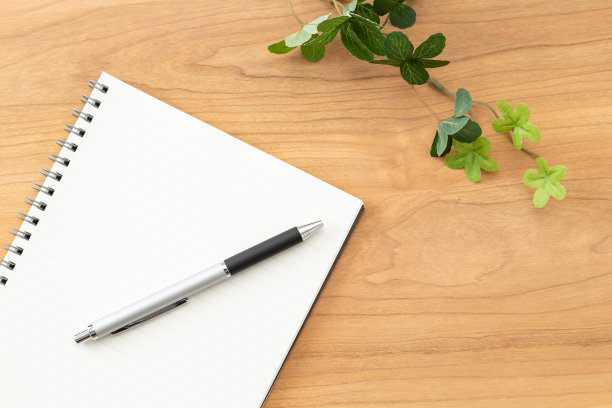 桌上有一个笔记本和一支笔。图片下载