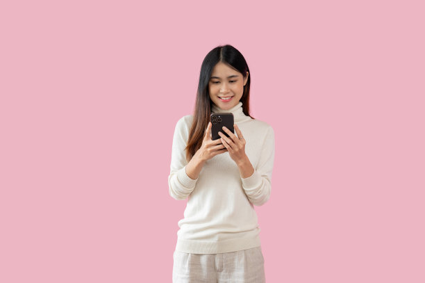 一个漂亮的亚洲女人正在用她的智能手机聊天，发短信或电子邮件图片下载