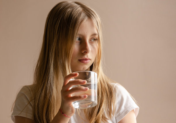 金发女孩喝了一杯水在家里凑近图片下载