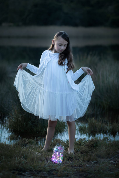 一个年轻女孩在黄昏时身穿白裙的全身画像图片下载