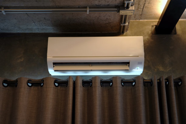 壁挂式空调安装在窗帘杆上方的混凝土壁上。图片下载