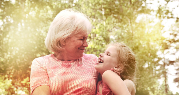 奶奶和孙女在公园的长椅上。坦诚交谈，开怀大笑。幸福的家庭。和爷爷奶奶在户外度过美好时光。爱，联系，结合的概念图片下载