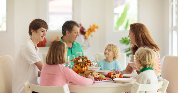 一家人和孩子一起吃感恩节晚餐。火鸡图片下载