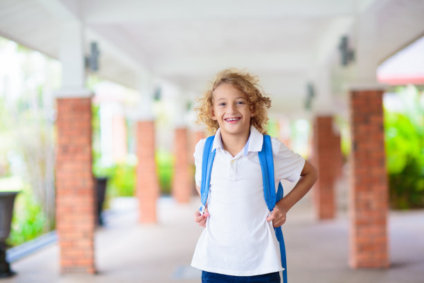 孩子们回到学校。快乐的学生背着书包。图片下载