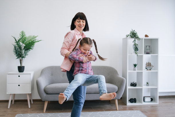 白天，妈妈在室内旋转着女儿图片下载