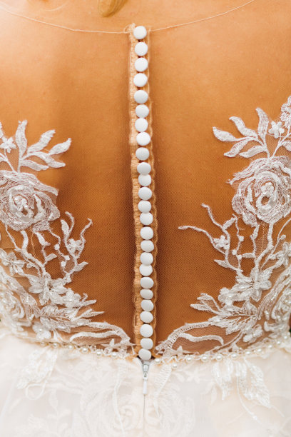 新娘的后背，她穿着一件有蕾丝和纽扣的漂亮礼服图片下载