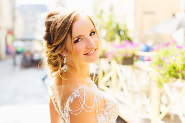 在一个阳光明媚的日子里，一位美丽的新娘看着镜头，可爱地微笑着图片下载