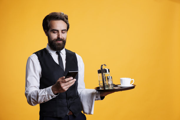优雅的服务员使用智能手机应用图片下载