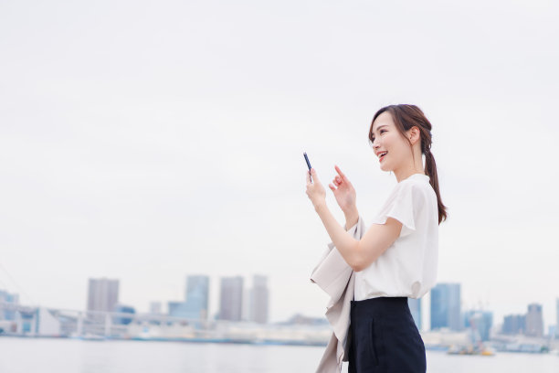 年轻女子在户外打字图片下载