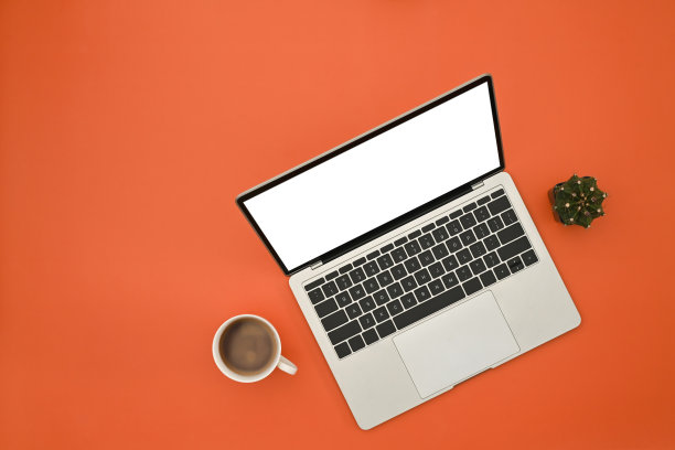 创意办公桌概念，笔记本电脑与空屏幕，咖啡杯在橙色的背景。图片下载