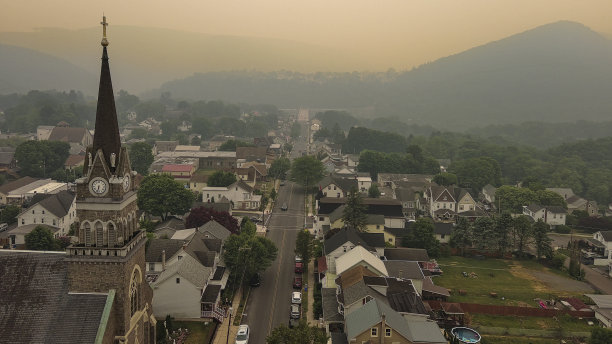 山城上空日落火焰烟雾的面纱:吉姆·索普在宾夕法尼亚州波科诺斯的阿巴拉契亚山脉烟雾笼罩的天空。图片下载