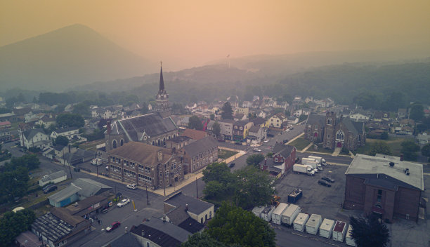 日落时分，吉姆索普的山间社区笼罩着薄雾。黄色朦胧的天空覆盖了阿巴拉契亚山脉，波科诺斯，宾夕法尼亚州。鸟瞰图图片下载