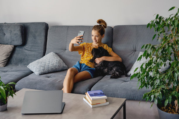 友谊的概念。十几岁的白人女孩在家里和她的狗自拍图片下载