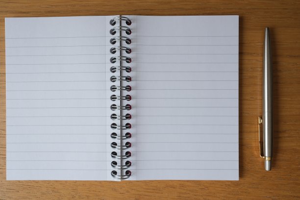 笔记本和笔在桌子上的特写图片下载