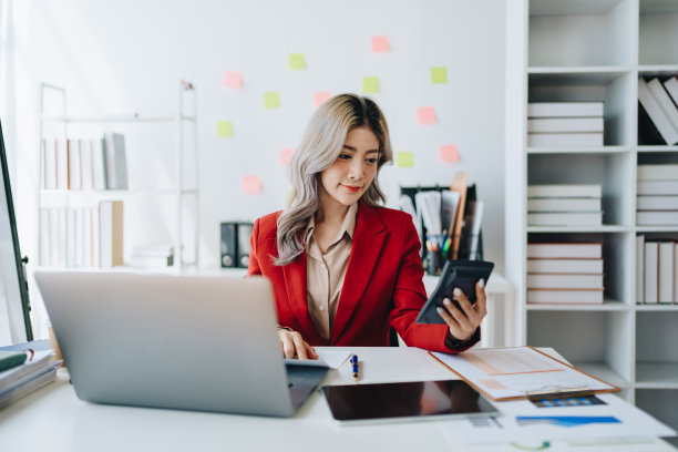 美丽的年轻的亚洲女商人使用电脑笔记本电脑和计算器计算与计划工作在财务文件，税务，外汇，会计和财务顾问图片下载