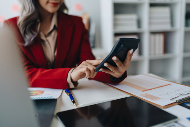 美丽的年轻的亚洲女商人使用电脑笔记本电脑和计算器计算与计划工作在财务文件，税务，外汇，会计和财务顾问图片下载