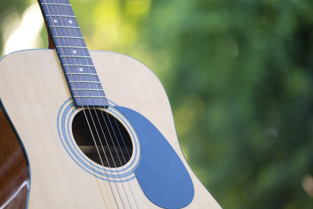 原声吉他户外绿色背景。平静音乐的概念图片下载