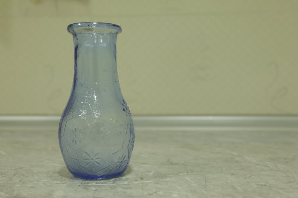 桌子上的空杯子和模糊的花瓶和花的背景。图片下载